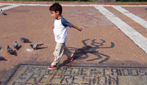 Boy walks past anti-repression graffiti, Buenos Aires