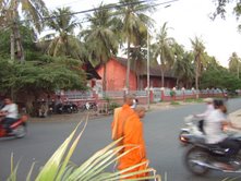 Monk and motorbikes in a Phnom Penh intersection.  
