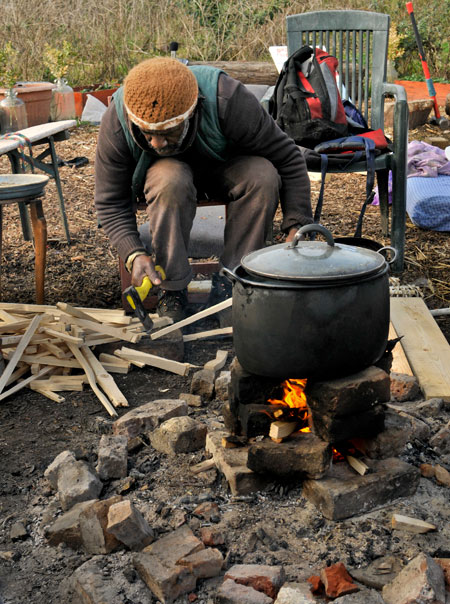 Michael, one of the eco-villagers, lights the evening fire and  boils water for green tea, April 2010.