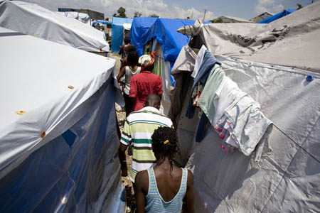 Displaced Haitians march through a camp during a protest demanding better housing policy.