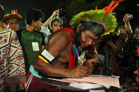 Member of indigenous delegation at Rio Summit signs declaration against green economy. Photo: Ben Powless