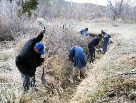 Spring cleaning of the acequia that irrigates Sol Feliz farm. (Photo by Miguel Santistevan.)