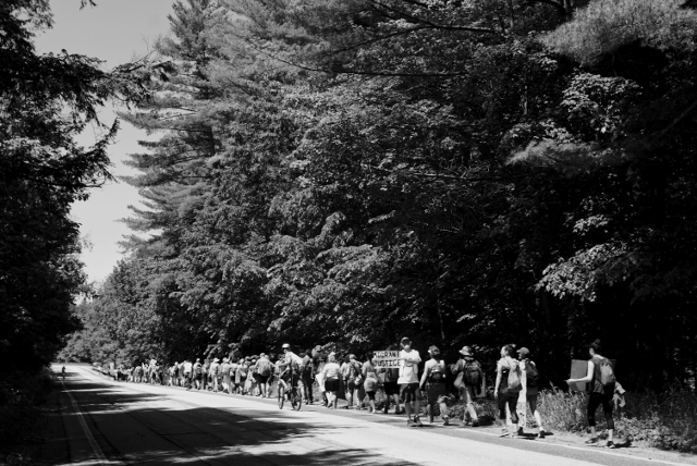 Marchers get a brief respite from the sun while passing through a thicket of woods along Route 2 in Moretown, VT.