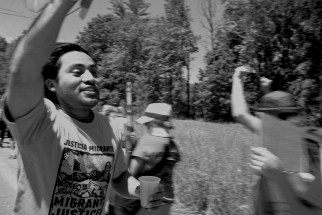 A migrant farmworker energizes his fellow marches with cries of "The people, united, will never be defeated!"