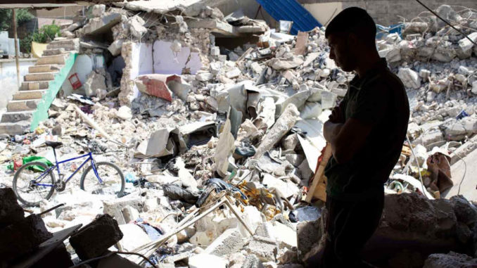 An Iraqi man looks at the ruins of a western Mosul house, destroyed in a March 17 coalition airstrike that killed more than 100 people. (AP Photo / Balint Szlanko)