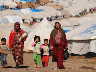 Syrian internally displaced people walk in the Atme camp, along the Turkish border in the northwestern Syrian province of Idlib, on March 19, 2013. Credit: Bulent Kilic/AFP/Getty Images
