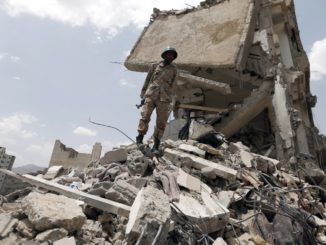 A Yemeni soldier stands on the debris of a house, hit in an airstrike on a residential district, in the capital Sana’a on Aug. 26, 2017. Credit: AFP