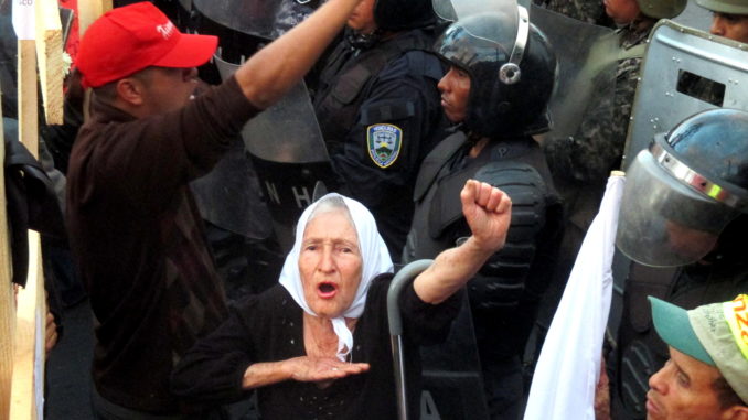 Dubbed a "grandmother of the resistance" after the 2009 coup d'état, Yolanda Chavarría sings the national anthem at a December 21st protest against election fraud outside the US Embassy in Tegucigalpa. She will turn 90 years old this year. Photo by Sandra Cuffe