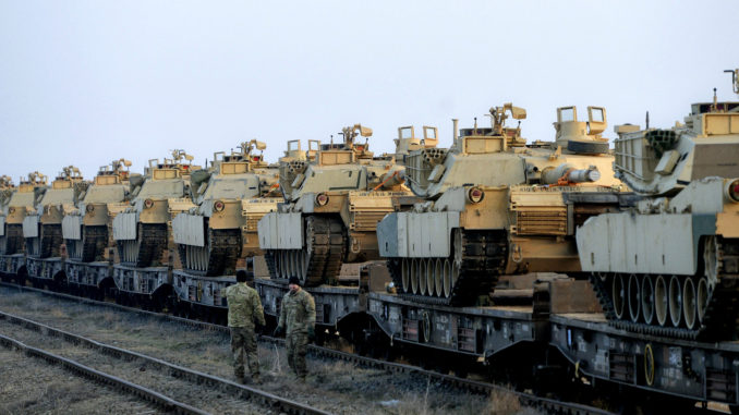 US soldiers from the 1st Battalion, 8th Infantry Regiment walk by a delivery of US tanks on February 14, 2017. Credit: AP/Andreea Alexandru