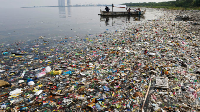 Fishermen set out amid floating garbage off the shore of Manila Bay in the Philippines on June 8, 2013. Photo Credit: Erik De Castro, Reuters