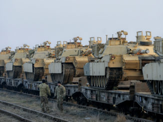 US soldiers from the 1st Battalion, 8th Infantry Regiment walk by a delivery of US tanks on February 14, 2017. Credit: AP/Andreea Alexandru