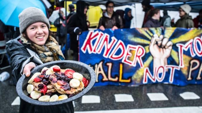 An activist at the January 29th demonstration shows an example of the type of pancake plate offered. (Photo courtesy of Mike Graeme)