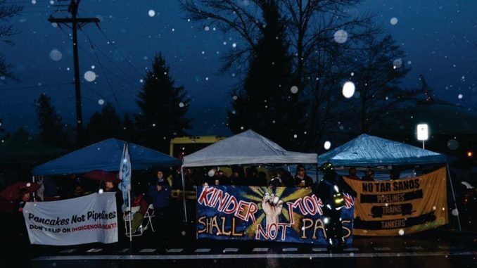 Rallying near a Kinder Morgan oil terminal, residents stood firm with their message from the morning until nightfall . (Photo courtesy of Murray Bush)