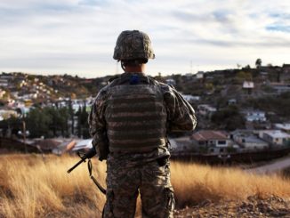 An Arizona National Guardsman watches over the U.S. border with Mexico at an observation post in Nogales, Arizona. Photo Credit: John Moore / Getty Images file
