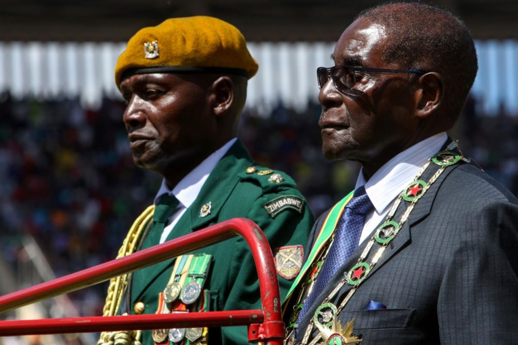 Zimbabwean President Robert Mugabe (right) at the country's independence anniversary in 2016. From early 1983 to late 1987, the Zimbabwe National Army carried out a series of massacres of Ndebele civilians called the Gukurahundi, deriving from a Shona language term which loosely translates to "the early rain which washes away the chaff before the spring rains". (Photo credit: Jekesai Njikizana/AFP/Getty) 
