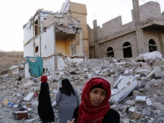 Yemeni women walk through the debris of a housing block allegedly destroyed by previous Saudi-led airstrikes in Sana'a, Yemen on Sept. 29. 2017. Photo credit: Yahya Arhab / EPA-EFE