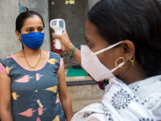 An Accredited Social Health Activist (ASHA) worker monitoring the temperature of a community member in Maharashtra’s Kolhapur district