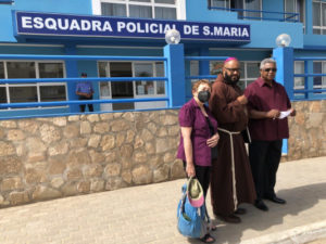 Bishop Felipe Teixeira (center), Pericles Tavares (right) and Sara Flounders (left) in front of a police station on the island of Sal in Cabo Verde, attempting to arrange a visit with detained Venezuelan diplomat Alex Saab / credit: International #FreeAlexSaab Solidarity Committee