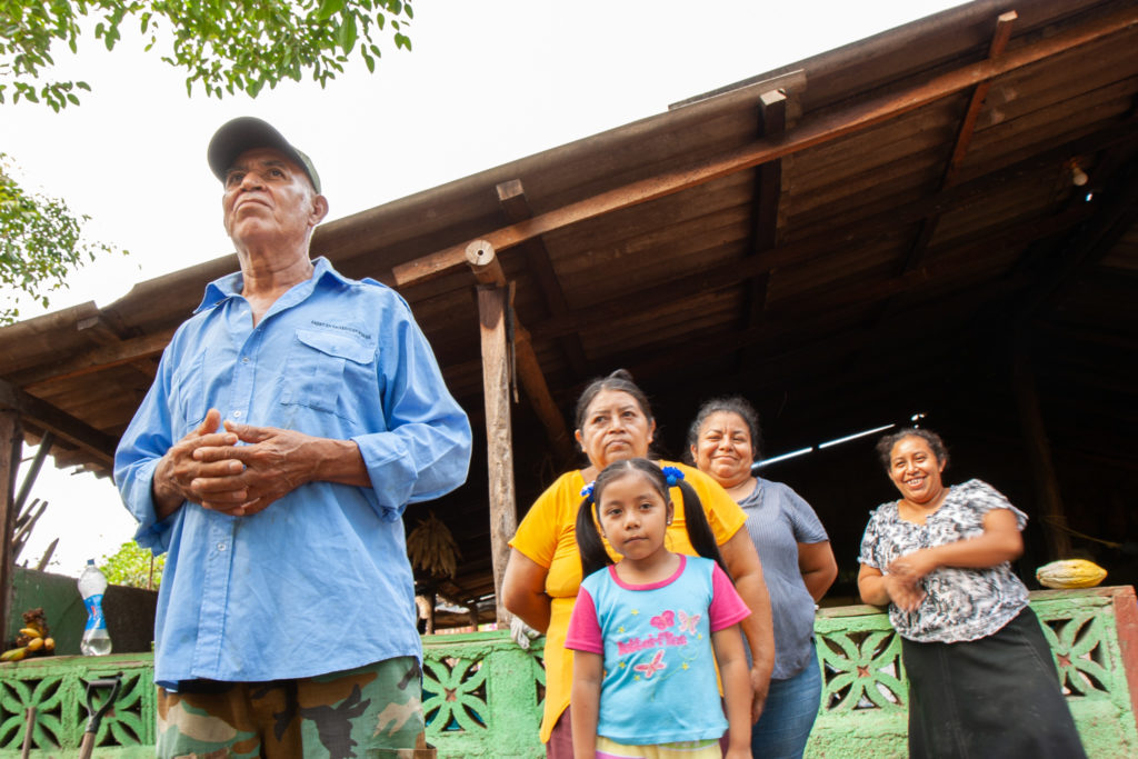 Victoriano Potosme (left), pictured with female relatives, speaks to a group of international visitors about the impact of the Sandinista Revolution on his family's life as they farm on land seized from white wealthy landowners in Ticuatepe, Nicaragua / credit: Julie Varughese