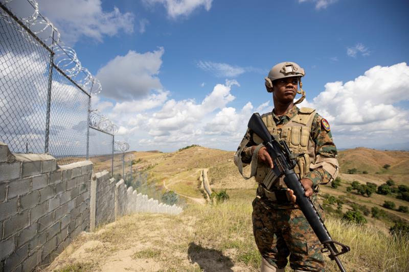 A Dominican soldier stands by a border wall the Dominican Republic built to keep out Haitian migrants / credit: La Prensa Latina