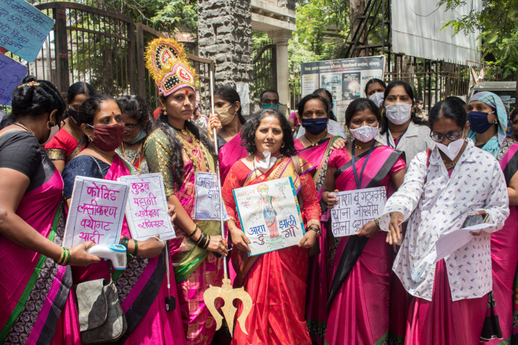 ASHA workers protesting outside the district collector’s office in Kolhapur city with placards mentioning their workload. In the center with a red saree is ASHA union leader Netradipa Patil, who has been fighting for better working conditions for over a decade / credit: Sanket Jain
