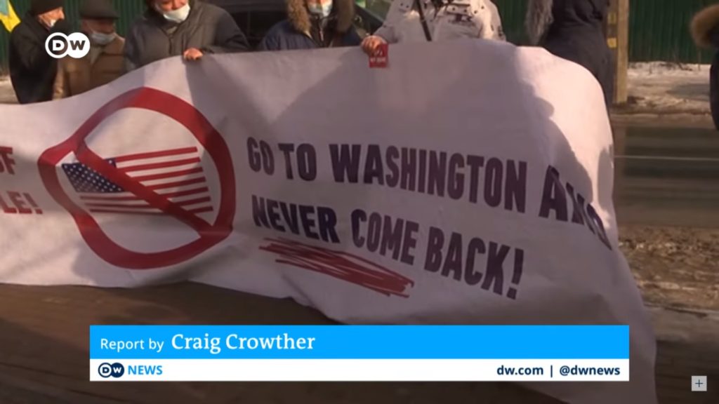 Screenshot of German public broadcaster Deutsche Welle showing Ukrainian protesters holding a banner that reads, "Go to Washington and never come back!" / credit: Deutsche Welle / Ukraine Peace Movement