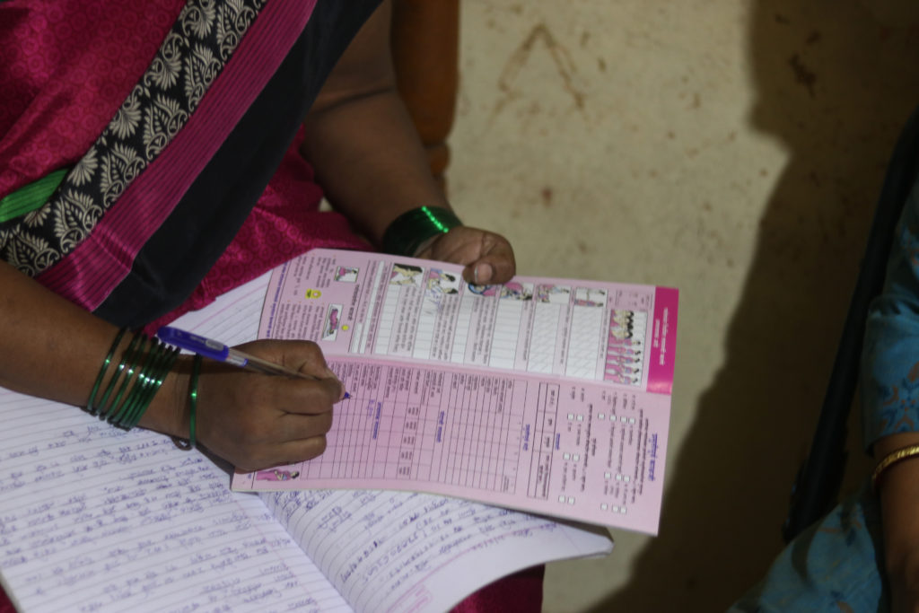 An ASHA worker filling the health records of a newborn in Kolhapur’s Shirol region, noting down important details / credit: Sanket Jain