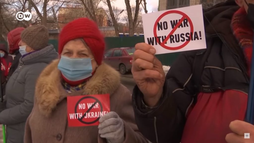 Protesters holding signs that read, "No war with Russia" (right) and "No war with Ukraine" / credit: Deutschewelle / Ukraine Peace Movement