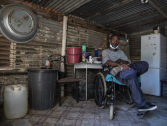 Zachariah Mokhothu inside the home he shares with his mother in the South African township of Kutlwanong. In his 15-year mining career, he got injured and developed tuberculosis before his paralysis / credit: Ihsaan Haffejee / New Frame