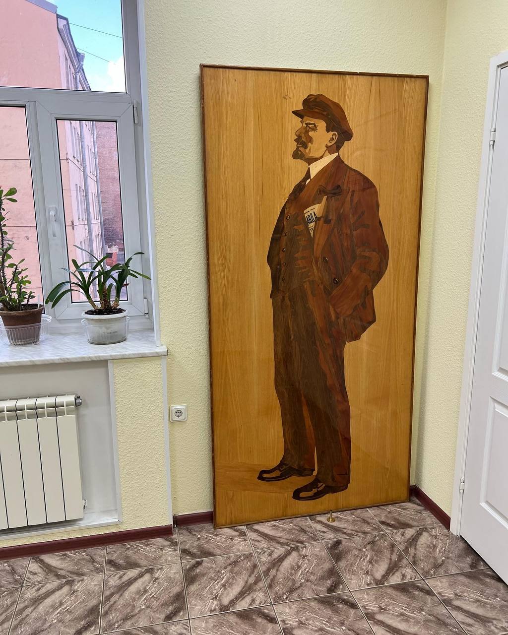 A carving of Bolshevik leader Vladimir Lenin in a wooden door at the KPRF office / credit: Fergie Chambers