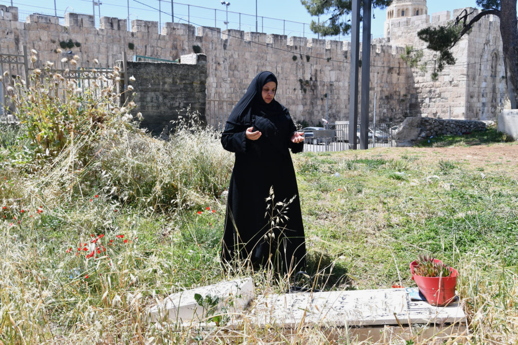 Ola Nababta prays at her son's grave in east Jerusalem's al-Yusufiya cemetery, over which Israel is threatening to build a park / credit: Jessica Buxbaum