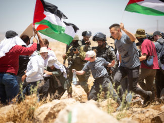 Israeli military personnel push a U.S. solidarity activist / credit: Emily Glick
