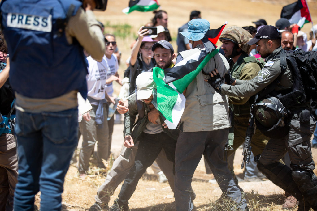 Israeli military personnel push activists protesting the seizure of the rural West Bank enclave of Masafer Yatta / credit: Emily Glick