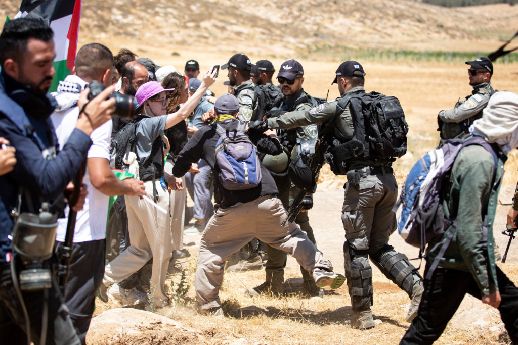 Israeli military personnel push solidarity activists / credit: Emily Glick
