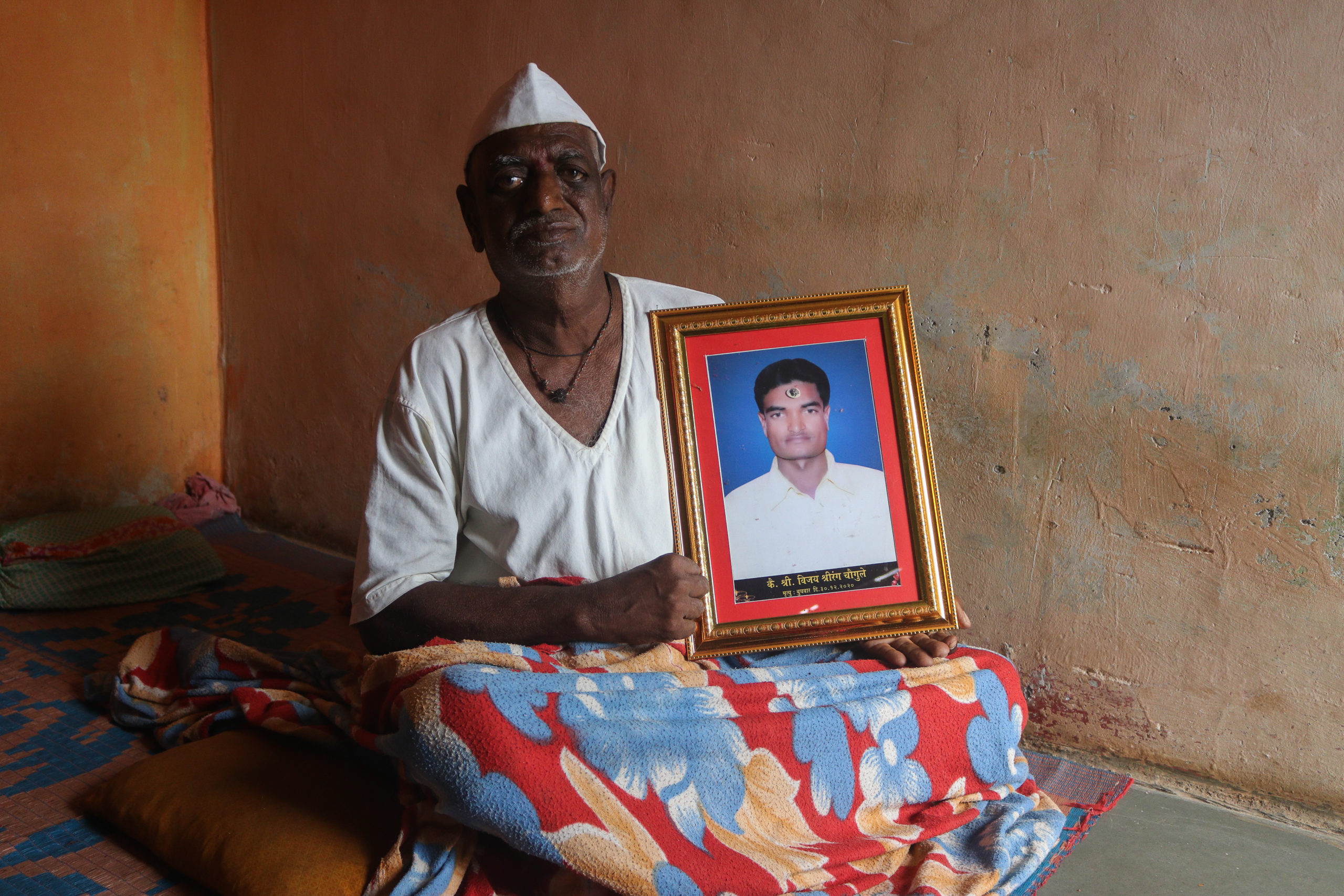 Shrirang Chougule, holding his son’s photo: “Even today, I can’t believe my son who was so strong and gave all of us hope died by suicide.” / credit: Sanket Jain