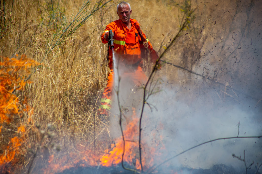 A Sicilian forest guard aerially fighting a fire on August 15. That day, a strong sirocco wind, a hot and dusty gust from northern Africa, and a temperature above 110 degrees Fahrenheit facilitated the rapid spread of fires across the island / credit: Antonio Cascio