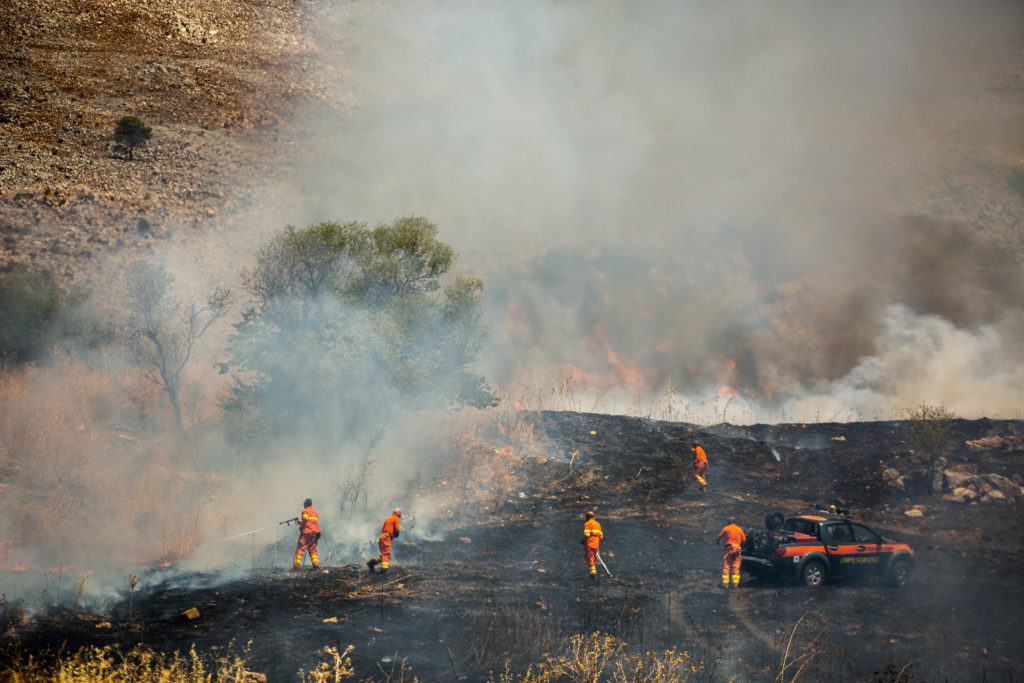 A member (on left) of the Sicilian Region Forestry Corps attempts to stop a fire from spreading across the Monte Sparagio mountain, which is designated as a Natura 2000 site, making it part of a network of European Union protected areas / credit: Antonio Cascio