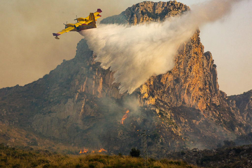 A Canadair firefighting aircraft from the Sicilian fire brigade sprays water onto a fire heading toward the Zingaro natural reserve in Sicily / credit: Antonio Cascio