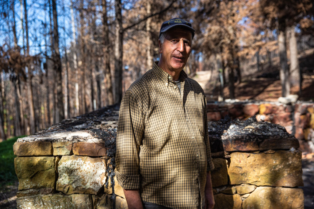 Giovanni Magaddino, 60, head of the Scorace Forest Squad in front of a burned cabin, which he helped build. The structure was considered a symbol of the forest / credit: Antonio Cascio