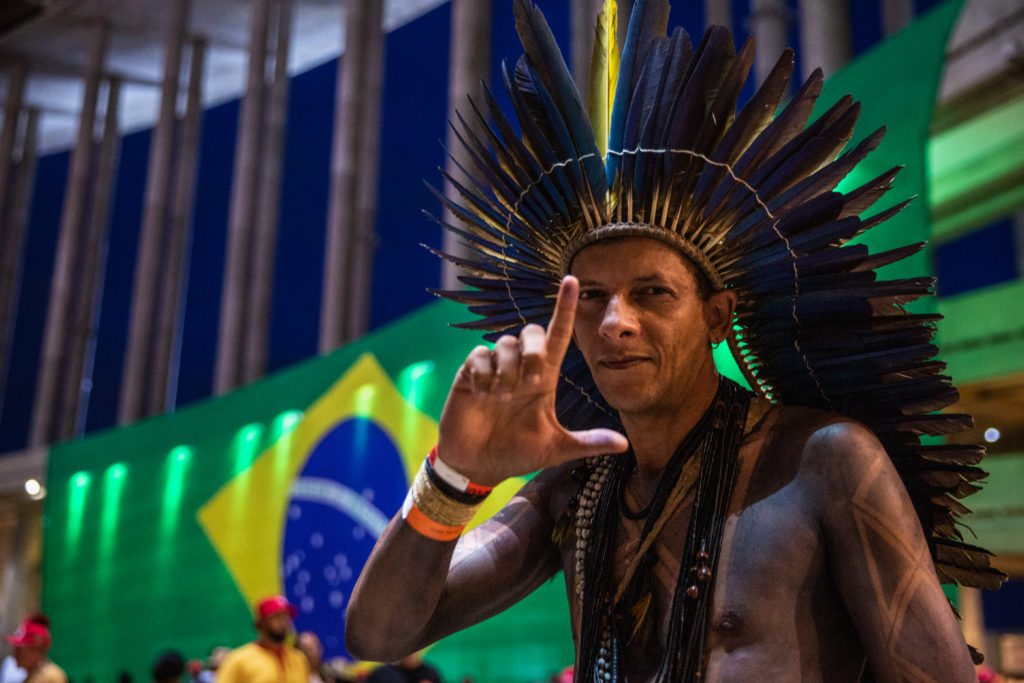 Indigenous Chief Junior Xukuru, advisor to the presidency of the CONAFER (National Confederation of Family Farmers and Rural Family Entrepreneurs), makes the gesture with his hand that represents support for President Luiz Inácio "Lula" da Silva. He is at the Brasilia Stadium's tent camp, which was organized for people who traveled from all over Brazil to attend Lula’s inauguration / credit: Antonio Cascio