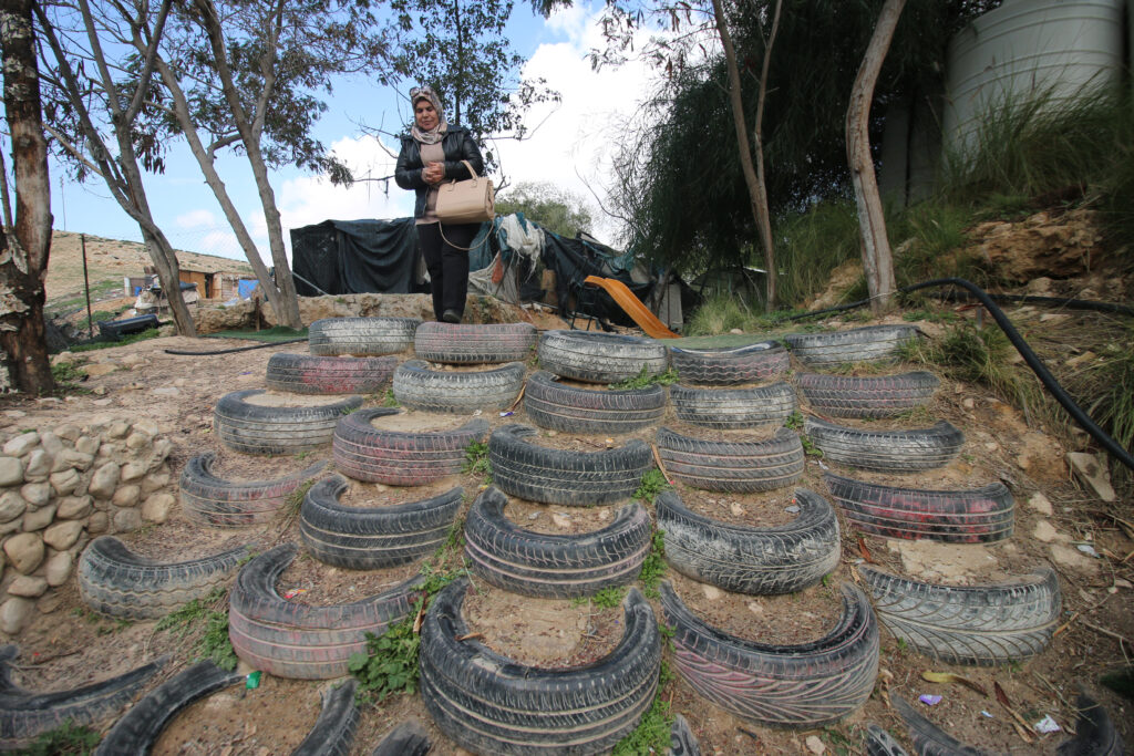 A Palestinian Education ministry official walks down tires that make up part of the structure of the compound for the Khan al-Ahmar school in the West Bank / credit: Ahmad Al-Bazz