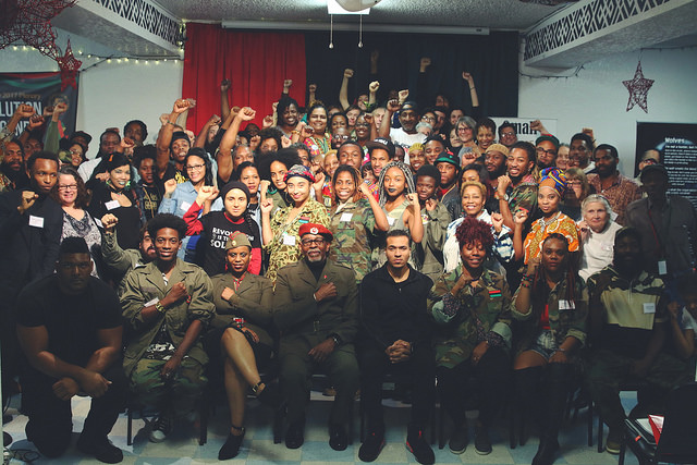 Attendees of the African People's Socialist Party (APSP) Plenary 2017. In the front row includes recently indicted defendants Gazi Kodzo (first from left with fist on chest), Omali Yeshitela (third from left with red beret) / credit: The Burning Spear