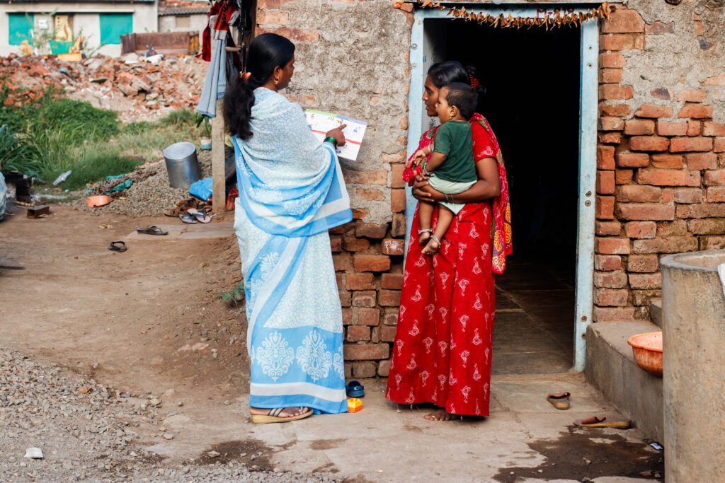 ASHA worker Shubhangi Kamble often works beyond her duty to ensure every child completes the universal immunization on time. Here, she speaks to a woman to help her understand how climate change can impact her son’s health / credit: Sanket Jain